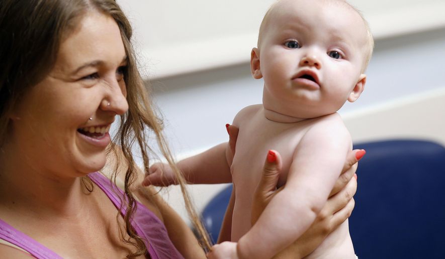 In this July 13, 2017 photo, Stephanie Gaffney bounces her daughter, Elliana, when she was 8 months old and visiting the neonatal-abstinence syndrome clinic at Cincinnati Children's Hospital Medical Center. The Cincinnati Enquirer is donating $5,000 of its 2018 Pulitzer Prize for local reporting to benefit Elliana featured in the newspaper's winning report on heroin. Gaffney died of an overdose of a fentanyl combination 10 days after speaking with the newspaper for the story. (Cara Owsley/The Cincinnati Enquirer via AP)