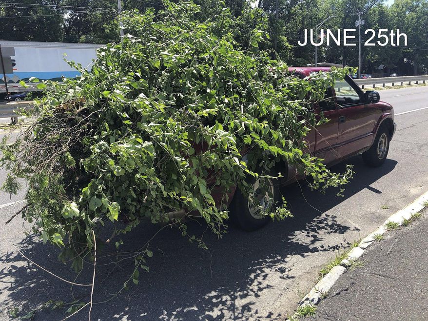 This June 25, 2018 photo released by the Chicopee Police Department shows an overloaded truck pulled over for uncovered cargo in Chicopee, Mass. The same unnamed driver was pulled over in by the Massachusetts State Police on June 20 for another unsecured load on Interstate 91 in Springfield. (Chicopee Police Department via AP)