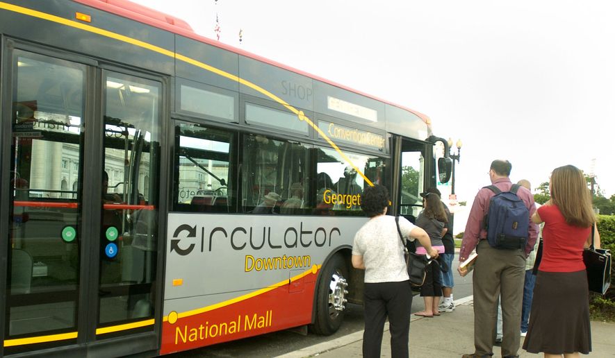 Riders wait to board the Downtown Circulator bus at a stop