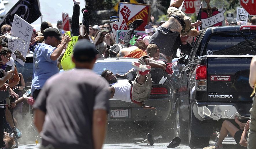 In this Aug. 12, 2017, file photo, people fly into the air as a vehicle is driven into a group of protesters demonstrating against a white nationalist rally in Charlottesville, Va. (Ryan M. Kelly/The Daily Progress via AP, File)
