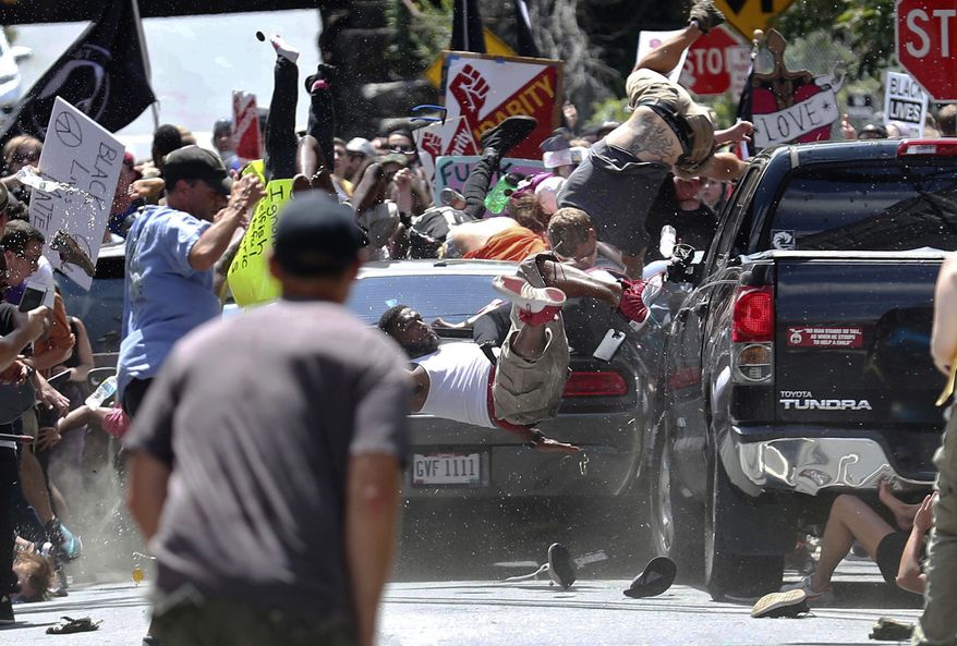 In this Aug. 12, 2017, file photo, people fly into the air as a vehicle is driven into a group of protesters demonstrating against a white nationalist rally in Charlottesville, Va. (Ryan M. Kelly/The Daily Progress via AP, File)