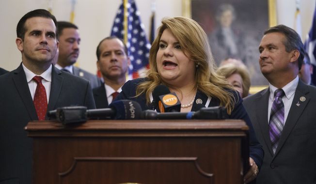 Puerto Rico&#x27;s Resident Commissioner, Jenniffer González-Colón, speaks during a ceremony on Capitol Hill in Washington, Wednesday, June 27, 2018, to present the Puerto Rico Admission Act of 2018, a bill to chart Puerto Rico&#x27;s transition from a territory to a State of the Union. She is joined by Puerto Rico Gov. Ricardo Rosselló, left, Rep. Don Bacon, R-Neb., right, and others (AP Photo/Carolyn Kaster)