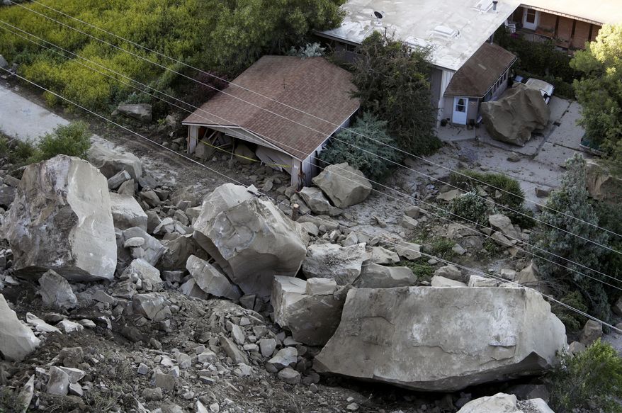 Boulders are scattered along a hillside and onto a property along the 220 block of Mountain View Blvd. following a rock slide, Wednesday, June 27, 2018, in Billings, Mont. (Casey Page/The Billings Gazette via AP)