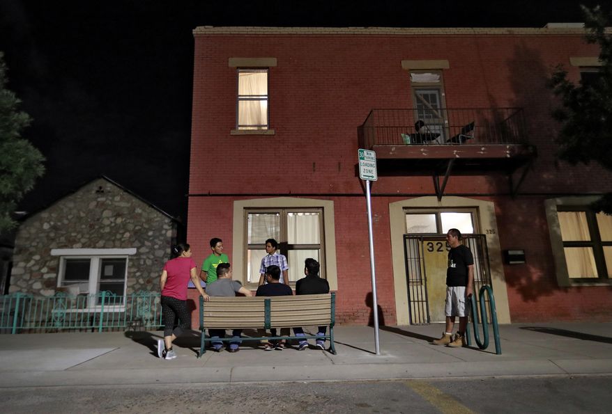 Migrant parents including Iris, from Honduras, left, Gustavo, from Guatamala, standing in green, Wilson Romero, from Honduras, standing, and Christian, from Honduras, seated in gray, socialize outside the Annunciation House, Tuesday, June 26, 2018, in El Paso, Texas. Thirty-two parents separated from their children are staying at the home as they wait to be reunited with their children. If the Trump administration has any hope of complying with a judge's order to reunite thousands of migrant children and parents within 30 days, it's going to have to clear away the red tape and confusion many immigrants have encountered so far. (AP Photo/Matt York)