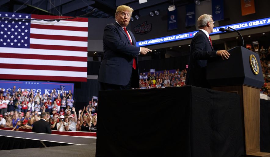 President Donald Trump points towards North Dakota Senate candidate Rep. Kevin Cramer, R-N.D., during a campaign rally, Wednesday, June 27, 2018, in Fargo, N.D. (AP Photo/Evan Vucci)