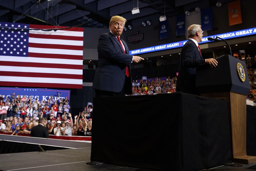 President Donald Trump points towards North Dakota Senate candidate Rep. Kevin Cramer, R-N.D., during a campaign rally, Wednesday, June 27, 2018, in Fargo, N.D. (AP Photo/Evan Vucci)