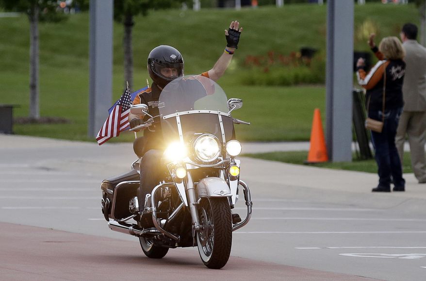 FILE - In this Aug. 2, 2013 file photo, Wisconsin Governor Scott Walker rides a Harley Davidson motorcycle to the motorcycle museum in Milwaukee. The ceremonial groundbreaking for a massive $10 billion Foxconn factory complex in Wisconsin was supposed to be evidence that the manufacturing revival fueled by President Donald Trump's "America First" policy is well underway. But an announcement this week by Harley-Davidson that it is moving some production of motorcycles overseas to avoid tariffs is fueling unease among voters in Wisconsin, a state Trump barely won and where fellow Republican Gov. Scott Walker is on the ballot. (AP Photo/Jeffrey Phelps, File)