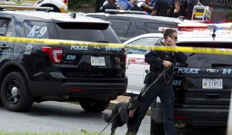 A K-9 police unit works the scene after multiple people were shot at a newspaper office building in Annapolis, Md., Thursday, June 28, 2018. (AP Photo/Jose Luis Magana)