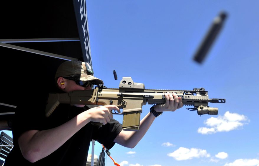 FILE - In this June 28, 2014 file photo, a bullet casing flies from the rifle as Derrick Campbell fires downrange at targets during the second annual Freedom Shoot at Pawnee Sportsmen Center near Briggsdale, Colo. The California Supreme Court will decide whether state laws can be challenged in court on the grounds that complying with them is impossible in a lawsuit over a California law that requires new models of semi-automatic handguns to stamp identifying information on bullet casings. (Joshua Poison/The Greeley Tribune via AP, file)