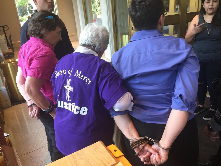 Eleanor Chavez, left, Marlene Perrotte, center, and Susan Schuurman, right, are arrested by New Mexico State Police at the Capitol in Santa Fe, N.M., on Thursday, June 28, 2018. Protesters from faith-based groups gathered to condemn Republican New Mexico Gov. Susana Martinez's support for federal immigration policies and ignored requests to leave as the building was closed to visitors. Martinez was traveling in Taiwan. (AP Photo/Morgan Lee)