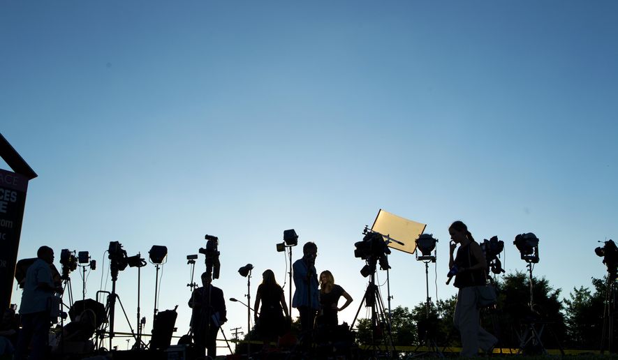TV crews waiting for a news conference line up at the side of the road across the newspaper office building where multiple people were shot this afternoon inside of the newsroom, in Annapolis, Md., Thursday, June 28, 2018. (AP Photo/Jose Luis Magana)
