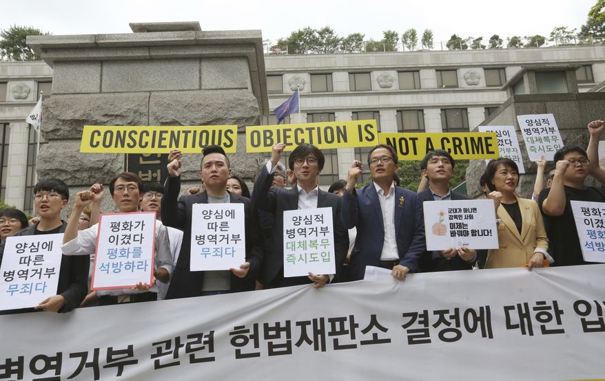 Activists for conscientious objectors stage a rally demanding the government to work out alternatives in front of the Constitutional Court in Seoul, South Korea, Thursday, June 28, 2018. South Korea's Constitutional Court has ruled that the country must allow alternative social service for people who conscientiously object to military service, which is currently mandatory for able-bodied males. The signs read: " We call for the government to work out alternatives." (AP Photo/Ahn Young-joon)