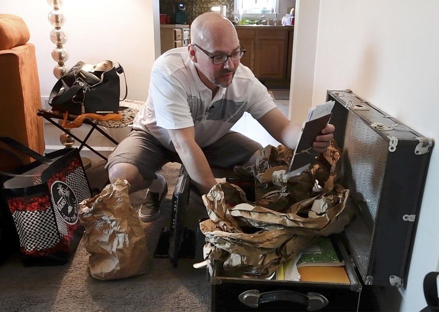 ADVANCE FOR WEEKEND EDITIONS, JUNE 30-JULY 1- In this June 19, 2018 photo, Michael Lehman, 44, pulls out an address book that he has had since the late 1990s from his black trunk in Marietta, Pa. Lehman says that everything he owns is contained in the trunk he brought with him from prison. Prison has pretty much been the only home he has ever had, having been behind bars since he was 14. (Paul Kuehnel/York Daily Record via AP)