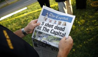 Steve Schuh, county executive of Anne Arundel County, holds a copy of The Capital Gazette near the scene of a shooting at the newspaper&#39;s office, Friday, June 29, 2018, in Annapolis, Md. A man armed with smoke grenades and a shotgun attacked journalists in the building Thursday, killing several people before police quickly stormed the building and arrested him, police and witnesses said. (AP Photo/Patrick Semansky)