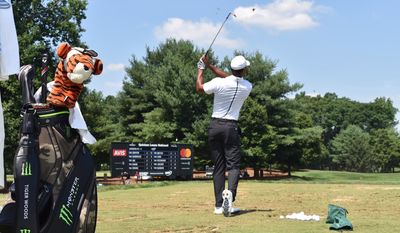 Tiger Woods hits range balls before the third round of the Quicken Loans National at TPC Potomac at Avenel Farm in Potomac, Md. on Saturday, June 30, 2018. The bag in the foreground will be autographed and auctioned off to benefit the charitable works of the TGR Foundation. (Photo courtesy of Quicken Loans National)