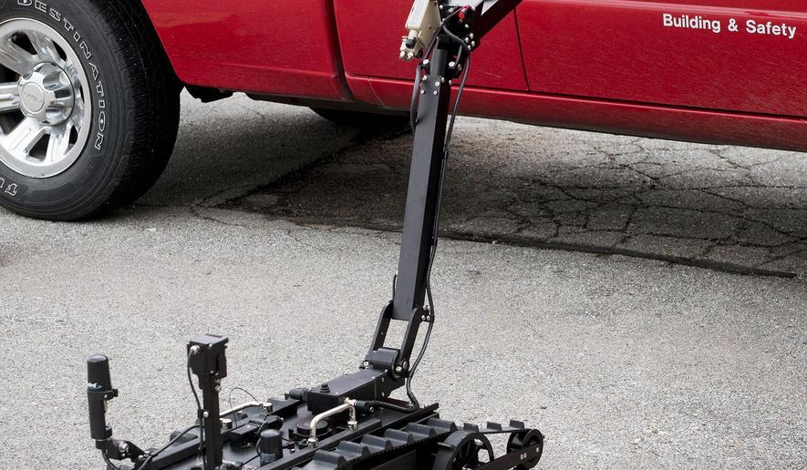 This June 19, 2018 photo shows a ICOR Technology Mini-CALIBER robot next to a fire investigator&#x27;s truck at Municipal Services Center in Lincoln, Neb. The new nimble, black, tracked tactical robot for Lincoln&#x27;s bomb squad won&#x27;t move faster than 5 mph, but its operators believe it could help the squad or a SWAT team defuse tense situations faster. (Francis Gardler/Lincoln Journal Star via AP)
