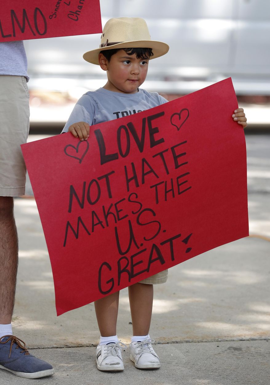 Four-year-old Carlos Gonzalez, of Marshalltown, Iowa, holds a sign during a rally to protest the Trump administration's immigration policies, Saturday, June 30, 2018, outside the Marshall County Courthouse in Marshalltown, Iowa. (AP Photo/Charlie Neibergall)