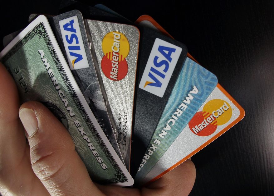 In this March 5, 2012 file photo, consumer credit cards are posed in North Andover, Mass. A new law set to take effect Sunday, July 1, 2018, will prohibit consumer credit reporting agencies from charging Georgia residents to freeze their credit report. Placing a freeze on your credit is a security measure that can be used to combat identity theft. It essentially prevents creditors from obtaining your credit report, making it nearly impossible to open a new account.Credit reporting agencies were previously allowed to charge a fee of up to $3 to freeze or unfreeze a report. (AP Photo/Elise Amendola, File)