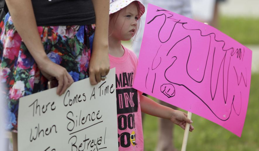 Chloe Morton, 4, listens to a speaker during a protest against separating immigrant families, Saturday, June 30, 2018, in Jackson, Mich. (Nikos Frazier/Jackson Citizen Patriot via AP)