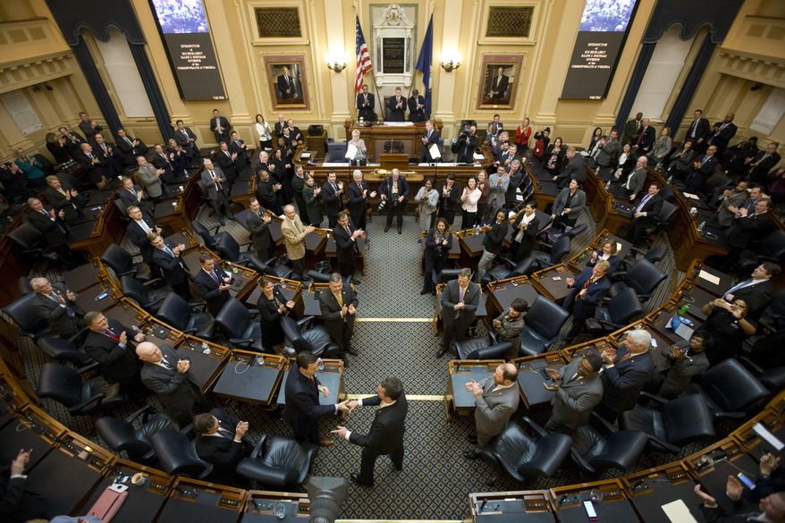 FILE - In this Jan. 15, 2018, file photo, Virginia Gov. Ralph Northam, center, arrives in the House Chambers to deliver his State of the Commonwealth address before a joint session of the Virginia General Assembly at the Capitol in Richmond, Va. Hundreds of new Virginia laws will be going into effect Sunday. Notable new laws include raising the felony threshold for shoplifting from $200 to $500; allowing school boards to increase time kids spend in recess; loosening restrictions on dogs visiting wineries and breweries; and legalizing slot-like machines at horse tracks and other locations. (AP Photo/Steve Helber)