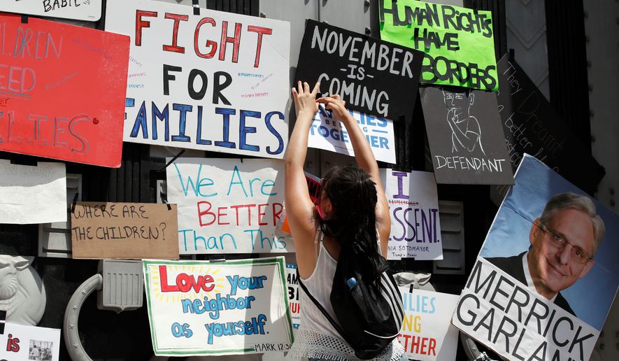 Activists have placed signs on the doors of the Department of Justice to protest immigration policy. (Associated Press)