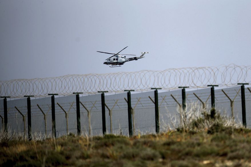 A helicopter flies over the British Royal Air Force base in Akrotiri, near the coastal city of Limassol in the eastern Mediterranean island of Cyprus, Thursday, April 12, 2018. British Prime Minister Theresa May summoned her Cabinet back from vacation to discuss possible military action against Syria over an alleged chemical weapons attack in Douma. (AP Photo/Petros Karadjias)