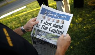 Steve Schuh, county executive of Anne Arundel County, holds a copy of The Capital Gazette near the scene of a shooting at the newspaper&#39;s office, Friday, June 29, 2018, in Annapolis, Md. A man armed with smoke grenades and a shotgun attacked journalists in the building Thursday, killing several people before police quickly stormed the building and arrested him, police and witnesses said. (AP Photo/Patrick Semansky)