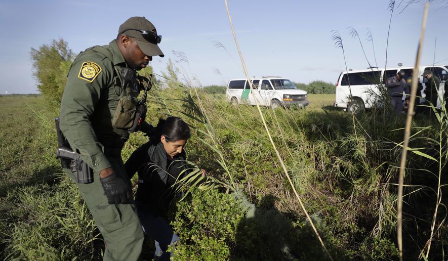 FILE - In this Aug. 11, 2017 file photo a U.S. Customs and Border Patrol agent escorts an immigrant suspected of crossing into the United States illegally along the Rio Grande near Granjeno, Texas. A U.S. official tells The Associated Press that Border Patrol arrests fell sharply in June 2018 to the lowest level since February, ending a streak of four straight monthly increases. The drop may reflect seasonal trends or it could signal that President Donald Trump's "zero-tolerance" policy to criminally prosecute every adult who enters the country illegally is having a deterrent effect. The official spoke on condition of anonymity because the numbers are not yet intended for public release. (AP Photo/Eric Gay, File)