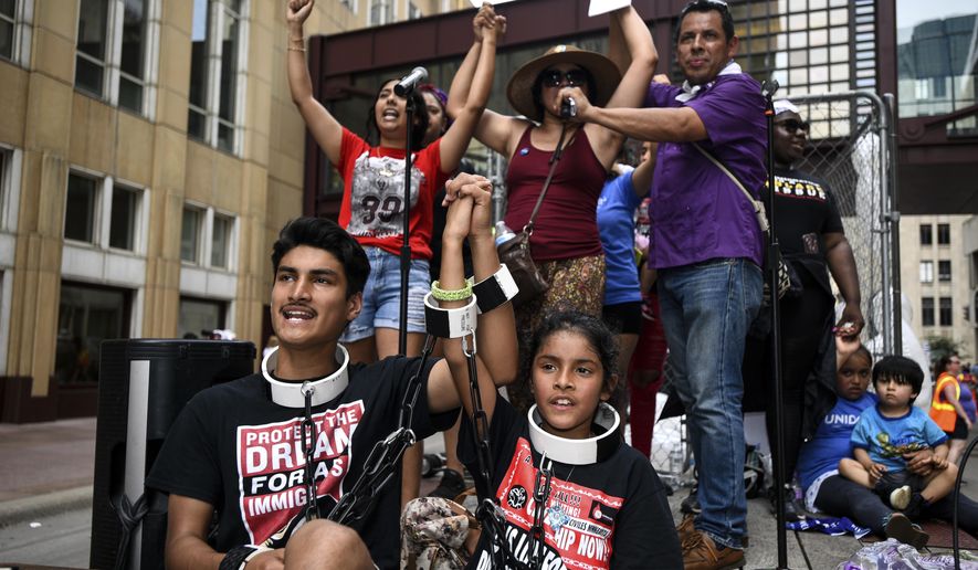 James Gutierrez, 15, and his sister, Lilah, 8, wore chains during a demonstration against the Trump administration's immigration policies Saturday, June 30, 2018.(Aaron Lavinsky/Star Tribune via AP)