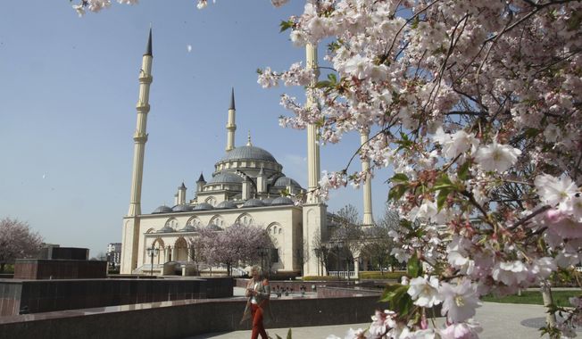 In this April 6, 2016, file photo, a woman walks outside the main mosque in the downtown Chechen regional capital of Grozny, Russia. (AP Photo/Musa Sadulayev, File)