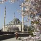 In this April 6, 2016, file photo, a woman walks outside the main mosque in the downtown Chechen regional capital of Grozny, Russia. (AP Photo/Musa Sadulayev, File)
