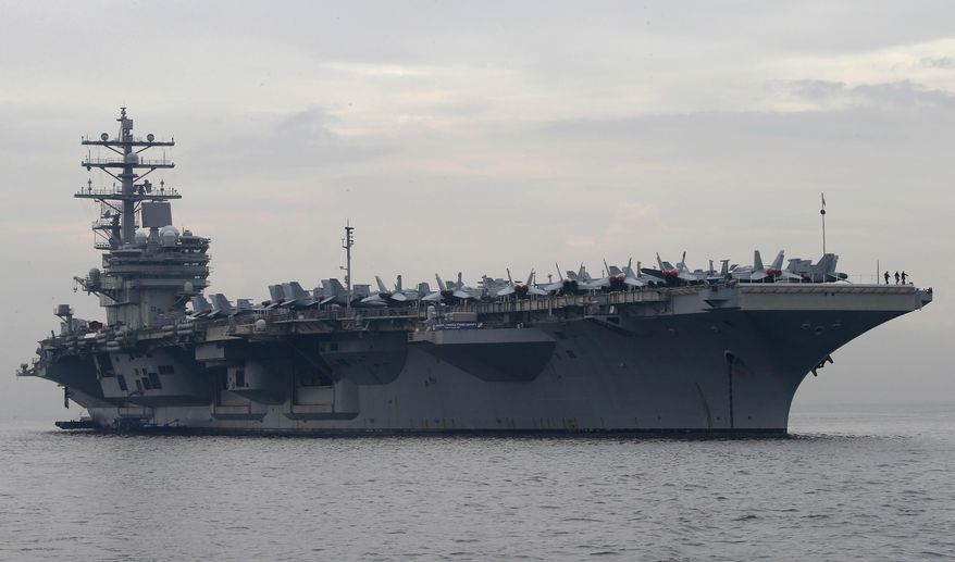In this June 26, 2018, file photo, the U.S. aircraft carrier USS Ronald Reagan anchors off Manila Bay for a goodwill visit in Manila, Philippines. The U.S. military has deployed the third aircraft carrier this year to patrol the South China Sea, where Washington has criticized China's military buildup on new man-made islands. (AP Photo/Bullit Marquez, File)