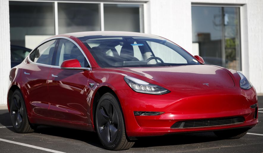 In this May 27, 2018, file photo, a 2018 Model 3 sedan sits at a Tesla dealership in Littleton, Colo. Tesla Inc. made 5,031 lower-priced Model 3 electric cars during the last week of June, surpassing its often-missed goal of 5,000 per week. Tesla reported making 28,578 Model 3s from April through June, according to its quarterly production release on Monday, July 2. (AP Photo/David Zalubowski, File)