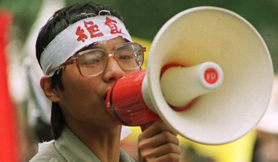 Chinese dissident Wang Dan addresses fellow students during a demonstration in Beijing&#39;s Tiananmen Square, in this May 1989  photo.  The characters on Wang&#39;s headband translate as &quot;hunger strike.&quot;  Fifteen years after the bloodshed, the exiled student leaders of China&#39;s 1989 pro-democracy protesters are settled abroad as academics and entrepreneurs. But they nurture one with above all - to come home to a new system. Wang Dan, a principal strategist for the protests, spent seven years in prison. Now 35, he is working toward a doctorate at Harvard University with a thesis on Chinese politics and history and the democratic movement in Taiwan. (AP Photo)