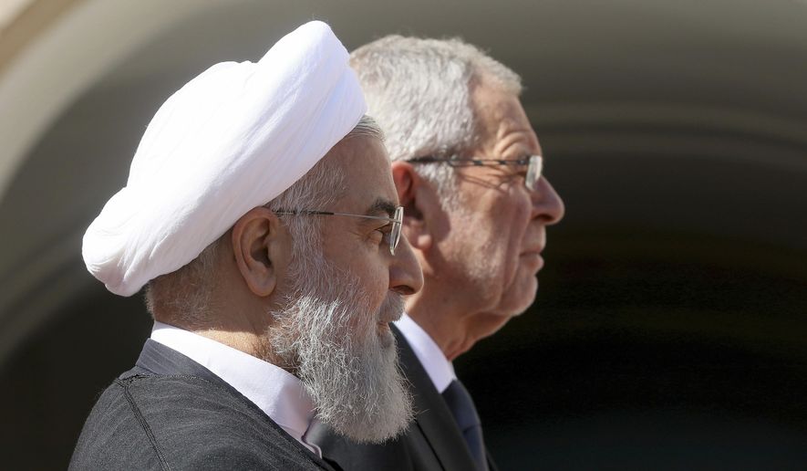 Iranian President Hassan Rouhani and Austrian President Alexander Van Der Bellen, right, attend a military welcome ceremony as part of a meeting in Vienna, Austria, Wednesday, July 4, 2018. (AP Photo/Ronald Zak)