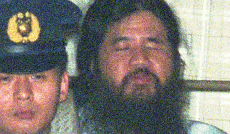 ** FILE ** Shoko Asahara, the guru of doomsday cult Aum Shinri Kyo, is driven away from the Tokyo District Court to the Metropolitan Police headquarters after a 10-day extension of his detention was approved in Tokyo in this July 7, 1995 photo. Asahara was sentenced to hang for leading a doomsday cult in a series of crimes culminating in a nerve-gas attack on Tokyo's subways that killed 12 and sickened 5,000 more just after the morning rush hour on March 20, 1995. In June, 2006, Asahara's lawyers filed a special petition with Japan's Supreme Court in what could be their last chance to keep him from going to the gallows. (AP Photo/Shizuo Kambayashi, FILE)