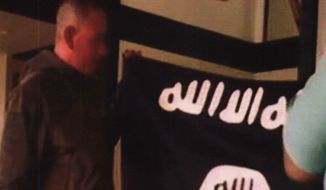 In this July 8, 2017, file image taken from FBI video and provided by the U.S. Attorney&#39;s Office in Hawaii on July 13, 2017, Army Sgt. 1st Class Ikaika Kang holds an Islamic State group flag after allegedly pledging allegiance to the terror group at a house in Honolulu. Newly unsealed court documents from an investigation into the Hawaii-based Army soldier accused of attempting to support the Islamic State group, provides more details about his obsession with the group&#39;s violence. (FBI/U.S Attorney&#39;s Office, District of Hawaii via AP, File)