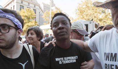 Therese Okoumou is surrounded by supporters as she leaves federal court, Thursday, July 5, 2018, in New York. Okoumou, who climbed the base of the Statue of Liberty on a busy Fourth of July in what prosecutors called a &quot;dangerous stunt&quot; pleaded not guilty Thursday to misdemeanor trespassing and disorderly conduct. A federal judge released  Okoumou without bail after her court appearance. (AP Photo/Mary Altaffer)