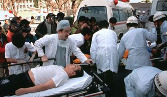 FILE - In this March 20, 1995, file photo, subway passengers affected by sarin nerve gas in the central Tokyo subway trains are carried into St. Luke&#39;s International Hospital in Tokyo. Japanese media reports say on Friday, July 6, 2018, doomsday cult leader Shoko Asahara, who has been on death row for masterminding the 1995 deadly Tokyo subway gassing and other crimes, has been executed. He was 63. (AP Photo/Chiaki Tsukumo, File)