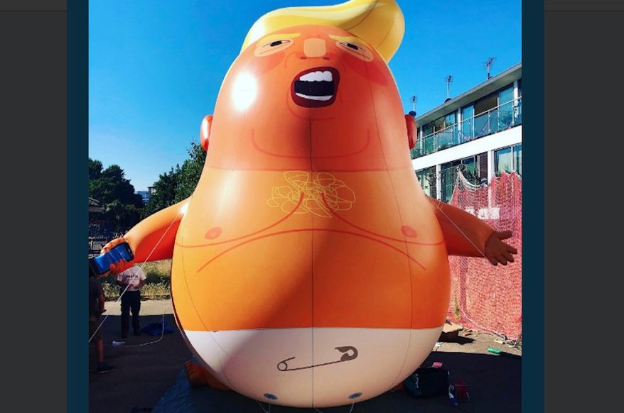 A 20-foot-high orange blimp portrays President Trump as an angry baby wearing a diaper and clutching a smartphone over Westminster near the Houses of Parliament in London. (Associated Press/File)