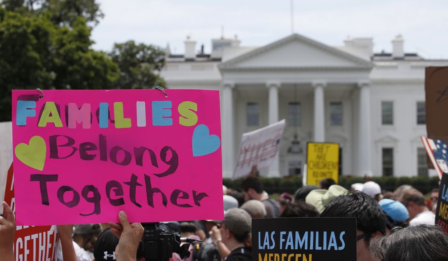 FILE - In this June 20, 2018, file photo, activists march past the White House to protest the Trump administration&#39;s approach to illegal border crossings and separation of children from immigrant parents in Washington. A Justice Department filing hours before a hearing Friday in San Diego says the administration needs more time to reunite all children with their parents by July 26 - and July 10 for children under 5. It says federal law requires it to complete reviews to ensure that the child is safe and that requires time.(AP Photo/Alex Brandon, file)