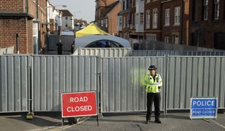 A police officer guards metal fencing erected as tents are set up behind, on the end of Rollestone Street, the location of the John Baker House for homeless people in Salisbury, England, Thursday, July 5, 2018. For the second time in four months, two people lie critically ill in England&#x27;s Salisbury District Hospital after being exposed to a military-grade nerve agent developed in the Soviet Union, British police confirmed late Wednesday. (AP Photo/Matt Dunham)