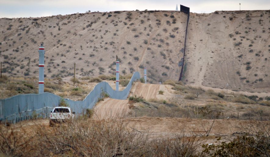 FILE - In this Jan. 4, 2016 file photo, a U.S. Border Patrol agent drives near the U.S.-Mexico border fence in Sunland Park, N.M. A new Cronkite News-Univision News-Dallas Morning News Border Poll released Monday, July 18, 2016, says a majority of residents surveyed on both sides of the U.S.-Mexico border are against the building of a wall between the two countries. The poll also suggests residents feel Democrats and Republicans are ignoring their concerns and aren&#39;t proposing solutions to help their economy and combat drug trafficking and human smuggling. (AP Photo/Russell Contreras, File)