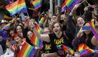In this June 28, 2015, photo, crowd waves rainbow flags during the Heritage Pride March in New York. (AP Photo/Kathy Willens) **FILE**