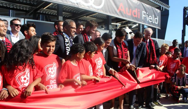 Muriel Bowser, the mayor of Washington, D.C., is joined by D.C. United CEO Jason Levien, D.C. Council member Jack Evans and children from the D.C. Scores community program in cutting a ceremonial ribbon outside Audi Field, the new Major League Soccer stadium, on Monday, July 9, 2018. (Photo by Adam Zielonka / The Washington Times)