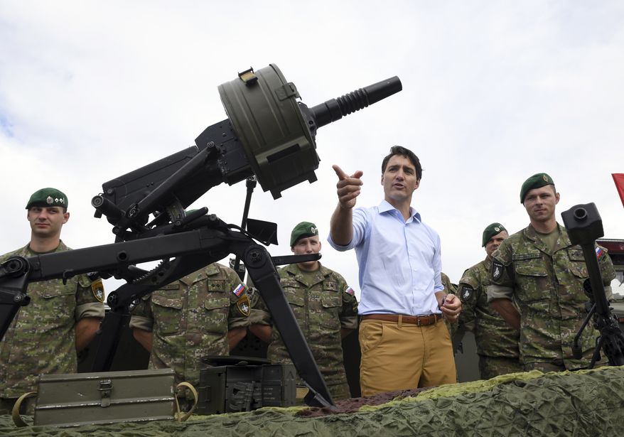 Canadian Prime Minister Justin Trudeau gestures while inspecting the troops as he visits Adazi Military Base in Kadaga, Latvia, on Tuesday, July 10, 2018. Canadian prime minister says he hopes the upcoming NATO summit will send a message of broad support for unity and solidarity but acknowledges that there will "no doubt be calls for greater investments in defense spending" - a key issue that is badly dividing the military alliance. (AP Photo/Roman Koksarov)