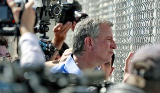 In this Thursday, June 21, 2018, file photo, New York City Mayor Bill de Blasio looks through a closed gate at the Port of Entry facility, in Fabens, Texas, where tent shelters are being used to house separated family members. U.S. Customs and Border Protection is alleging that de Blasio illegally crossed from Mexico into the U.S. while visiting the El Paso, Texas, area in June, an accusation the mayor’s office flatly denies. (AP Photo/Matt York, File)