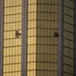 FILE - In this Oct. 2, 2017 file photo, drapes billow out of broken windows at the Mandalay Bay resort and casino on the Las Vegas Strip, following a mass shooting Oct. 1 at a music festival in Las Vegas. Aerial footage taken after the deadliest mass shooting in modern U.S. history shows the broken windows of a Las Vegas Strip casino-hotel suite where the gunman fired at a crowd gathered for a music festival. Videos released Wednesday, July 11, 2018, by police under court order also show the usually bustling Strip blocked off; runways and planes at McCarran International Airport; and officers pointing their weapons and restraining two people about a mile from the site of the shooting. (AP Photo/John Locher, File)