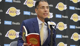 Los Angeles Lakers general manager Rob Pelinka reads a passage from &amp;quot;The Alchemist&amp;quot; by Paulo Coelho as talks about the acquisition of LeBron James and other free agents at a news conference at the NBA basketball team&#39;s headquarters in El Segundo, Calif., Wednesday, July 11, 2018. (AP Photo/Reed Saxon)