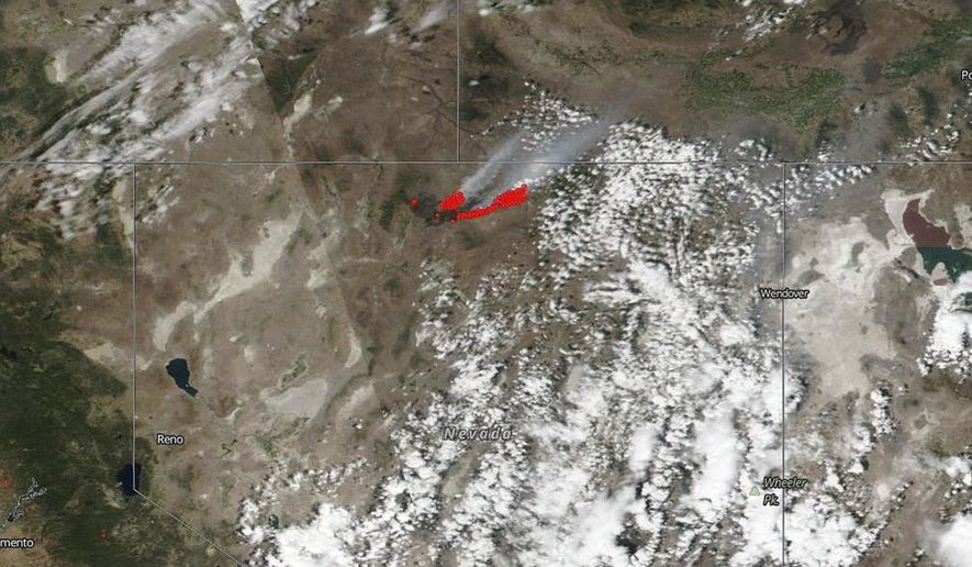 This July 8, 2018 satellite image from NASA's Suomi NPP satellite shows a wildfire, shown in red, also known as the Martin Fire, in Nevada, and smoke reaching to Idaho. The NASA satellite captured infrared imaging of the fire that has burned nearly 700 square miles (1,813 sq. kilometers) of mostly sage brush, grasses and rangeland, an area almost half the size of the state of Rhode Island, according to the NASA/Goddard Space Flight Center. (NASA via AP)